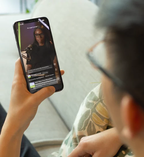 Aspiring solicitor watching the HLC Legal Lounge Podcast on a smartphone.