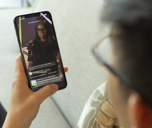Aspiring solicitor watching the HLC Legal Lounge Podcast on a smartphone.