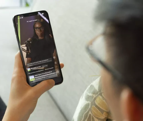 Aspiring solicitor watching the HLC Legal Lounge Podcast on a smartphone.